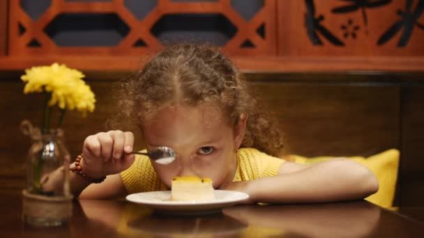 Kind zit op café en eten cheesecake. Close-up. — Stockvideo