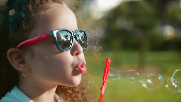 Buon bambino che soffia bolle di sapone nel parco. Rallentatore. Filmati delle scorte . — Video Stock