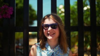 Kameraya bakarak gülen sevimli güzel sarışın genç neşeli kız yakın çekim portresi. Stok görüntüleri. Ağır çekim.