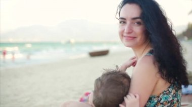 Büyüleyici bir anne kucağında bir bebekle portresi. Anne Bebek ile temiz hava zevk, Anne Anne sütü bebeği ve onu lulling.