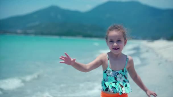 Aranyos kislány fut le a strand felé, az anyja, az egy nagy ölelés, és csók. Zár megjelöl szemcsésedik. Stock footage — Stock videók