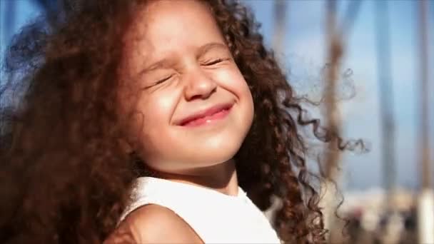 Petite jolie portrait de fille dans le parc. Concept de bébé et de beauté naturelle. Bouclez-vous. Beautihul Petite fille qui tourne dans le parc et sourit. Images de stock . — Video