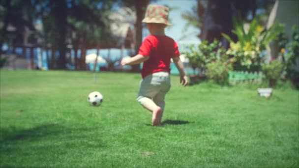 Милый мальчик играет в футбол. Съемка . — стоковое видео