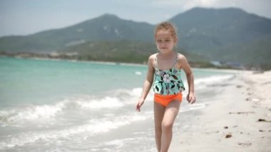 Sevimli küçük kız sahilde annesi kocaman bir kucak ve öpücük için doğru çalışır. Atış kapatın. Stok görüntüleri