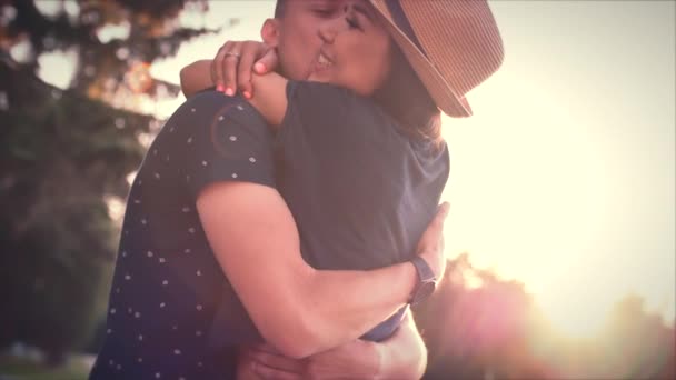 Mooie jonge verliefde paar kussen in de zon. — Stockvideo