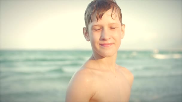 Закройте портрет красивого мальчика-подростка на пляже. Съемка . — стоковое видео