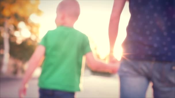 Familia feliz, padre e hijo felices caminando con el hijo cogido de la mano. Material de archivo — Vídeos de Stock