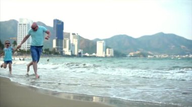 Genç Aile, baba ve kız sahil boyunca çalıştırın. Mutlu aile, sahil yürüyüş.