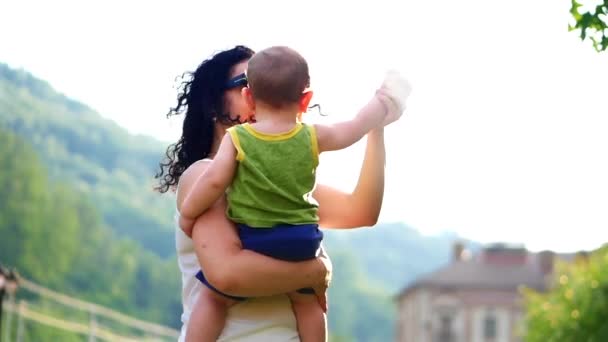 De unge danserna på mammor händer. Mamma leker med barnet. — Stockvideo