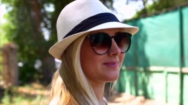 Bir güzel görünüm ve doğal ile harika gülümseyen kadın yapmak kamera ve saçlarını hareketli rüzgar bakarak.