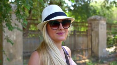 Bir güzel görünüm ve doğal ile harika gülümseyen kadın yapmak kamera ve saçlarını hareketli rüzgar bakarak.