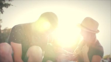 Mutlu aile, Anne, baba ve oğul parkta çim üzerinde oturan ve mutlu bir şekilde gülümseyerek. Stok görüntüleri