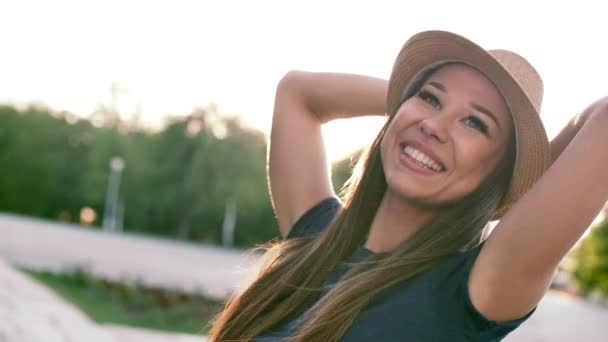 Mujer hermosa feliz haciendo forma de corazón con las manos al atardecer Chica sosteniendo el gesto símbolo de amor con destello de sol naranja . — Vídeos de Stock