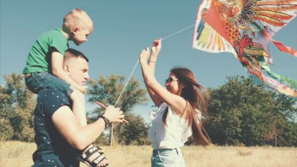 Gelukkige familie, moeder, vader en zoon lopen in de natuur, de lancering van een lucht-slang. Beeldmateriaal. — Stockvideo