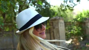 Bir güzel görünüm ve doğal ile harika gülümseyen kadın yapmak kamera ve saçlarını hareketli rüzgar bakarak.