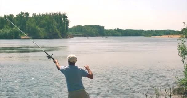 Marinheiro lança um equipamento de pesca na água . — Vídeo de Stock