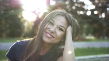 Genç mutlu kadın gülümsüyor, saç rüzgarda kamera bakıyor. Stok görüntüleri. Ağır çekim.