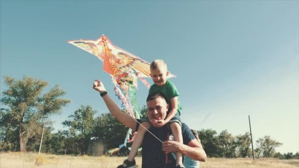 Glückliche Familie, Mama, Papa und Sohn gehen in der Natur spazieren und starten eine Luftschlange. Archivbild. — Stockvideo