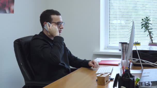 Επιχειρηματίας στην εργασία μιλάει στο κινητό από το τραπέζι στο γραφείο. — Αρχείο Βίντεο