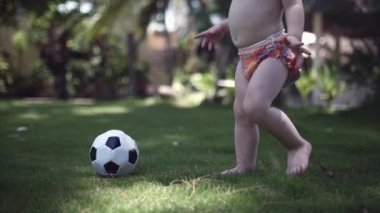 Bir iki-yıl-yaşlı çocuk parkta futbol oynamak, koşmak ve topu tekmelemek seviyor.