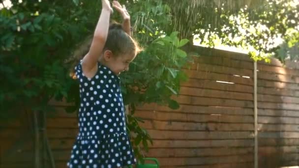 Bebê está brincando com água, em um dia quente ensolarado . — Vídeo de Stock