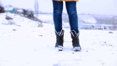 Yakın çekim portre alt görünümünden, genç kızın ayak snowsmiling üzerinde yürümek..