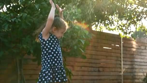 Bebê está brincando com água, em um dia quente ensolarado . — Vídeo de Stock