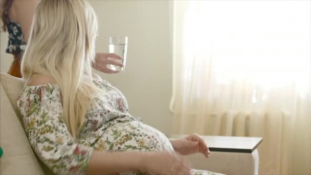 Femme apporte un verre d'eau à une femme enceinte — Video