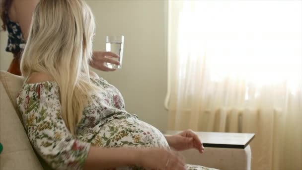 Porträt einer schwangeren Frau, die Wasser trinkt. — Stockvideo