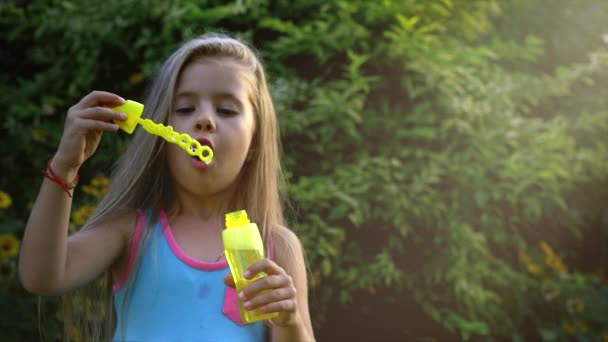 Lyckligt barn blåsa såpbubblor i park. Slow motion. Arkivfilmer. — Stockvideo