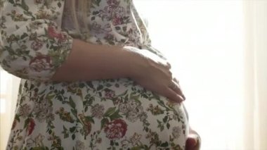 Hamile kadın, aktif olarak kendi göbek okşayarak.