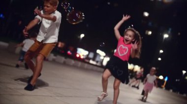 Sabun köpüğü ile parkta oynayan çocukların mutlu grup. Çocuklar sabun köpüğü akşam parkta yakalamak.