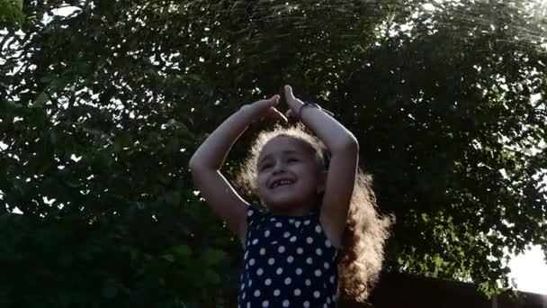 Baby spielt mit Wasser, an einem sonnigen heißen Tag. — Stockvideo