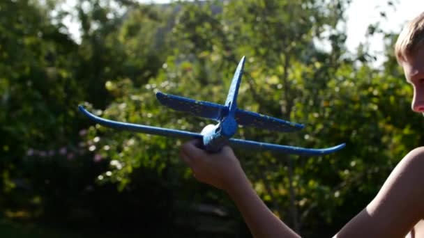快乐的孩子玩飞机在运行在日落背景的手. — 图库视频影像