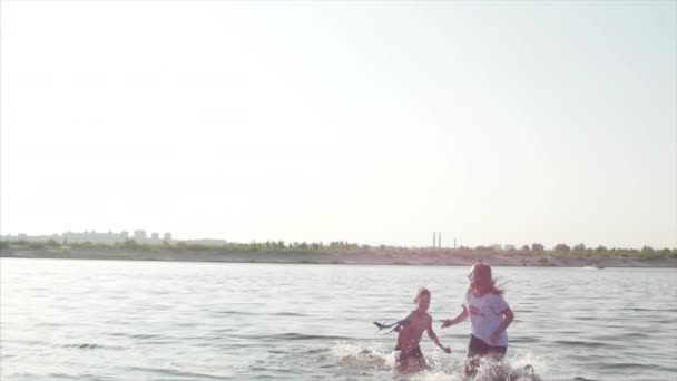 Enfance heureuse et insouciante. Enfants Jouer avec un chien, courir le long du sable, rire, jouer sur la rivière, lancer un avion jouet . — Video