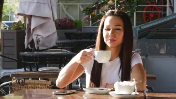 Mujer joven y atractiva tomando café en la calle . — Vídeos de Stock