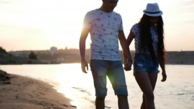 Mutlu çifte sarılma deniz dalgaları üzerinde yalınayak kumsalda yürüyüş kıyı strolling elele.