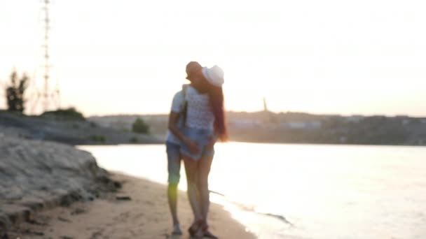 Casal feliz de mãos dadas passeando ao longo da costa, andando na areia descalço sobre as ondas do mar, abraçando . — Vídeo de Stock