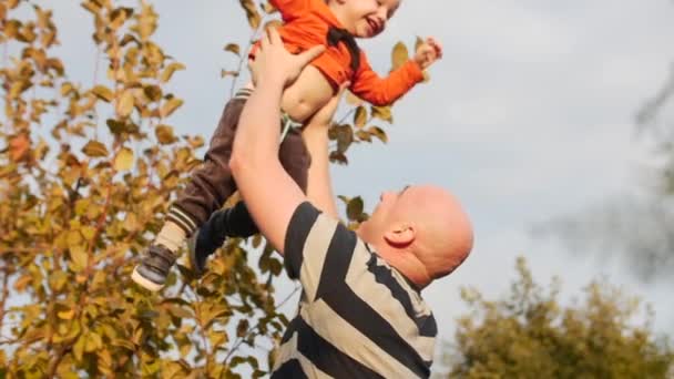 Concepto familia feliz. Padre lanzando a su adorable hijo en el aire . — Vídeos de Stock