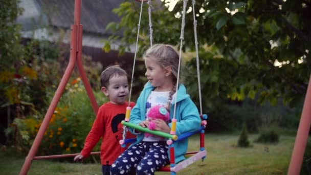 Zwei glückliche hübsche Kinder, die sich an der frischen Luft an den Händen halten und spielen. — Stockvideo