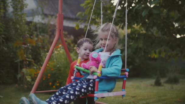 Zwei glückliche hübsche Kinder, die sich an der frischen Luft an den Händen halten und spielen. — Stockvideo