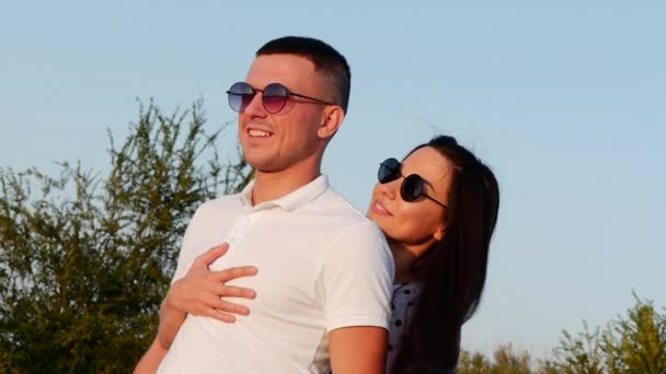 Beautiful Happy Stylish Joyful Young European Cute Couple in Black Glasses with Beautiful Smiles in Each other Arms . — стоковое видео