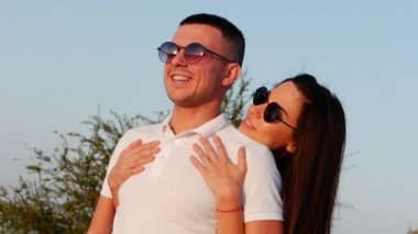 Güzel mutlu şık neşeli genç Avrupa şirin çift siyah gözlük ile her diğer kollarında güzel gülümsüyor.