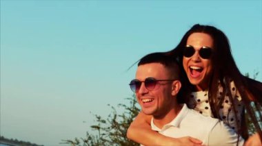 Güzel mutlu şık neşeli genç Avrupa şirin çift siyah gözlük ile her diğer kollarında güzel gülümsüyor.