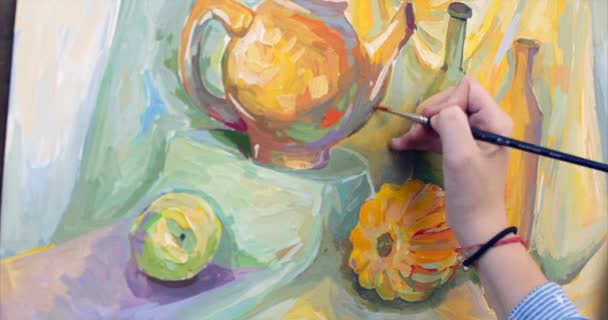 Una giovane bella artista femminile è in uno studio d'arte, seduta dietro una anguilla e pittura su tela. Processo di disegno: nello studio d'arte degli artisti mano Art Girl con una pittura a pennello su tela.4K — Video Stock