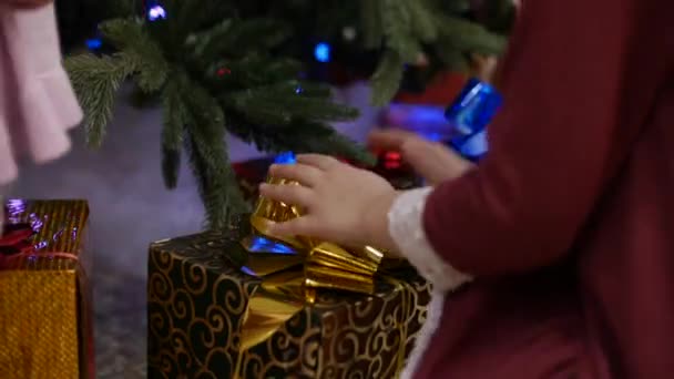 Twee kleine meisjes Sat Down te demonteren van de giften van Kerstmis van Santa Claus, op zoek naar de verleidingen van een wonder. — Stockvideo