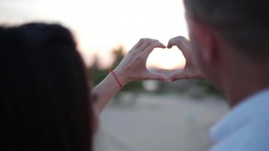 Güzel mutlu şık neşeli genç Avrupa şirin çift kollarında her diğer yapar bir romantik aşk fikir bir kalp şeklinde elinde. Aşk kavramı.