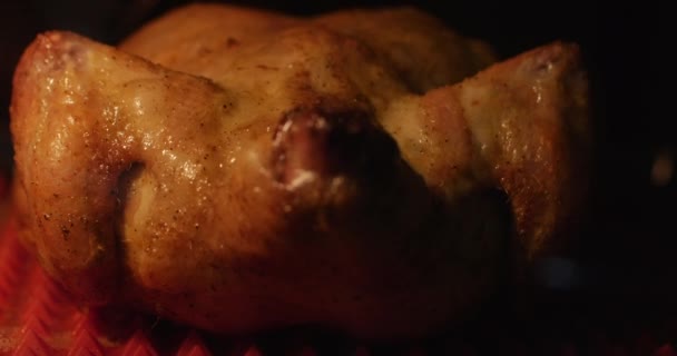 Preparación de pollo crujiente frito entero con especias en el horno, cocido en una estufa eléctrica . — Vídeo de stock