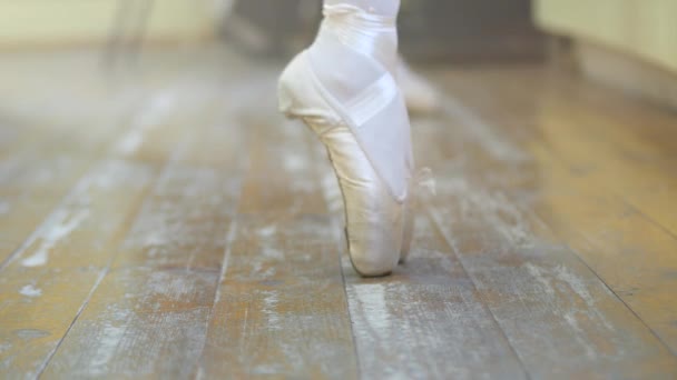 Ballet.Primer plano de las piernas de una niña en zapatos de ballet blanco durante el entrenamiento de ballet. Elemento de la danza clásica. 4K — Vídeos de Stock