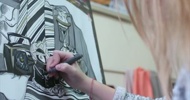 Jeune belle artiste féminine est dans un studio d'art, assis derrière un chevalet et peinture sur toile. Processus de dessin : dans l'atelier d'art des artistes Hand Art Girl with a Brush Painting on Canvas.4K — Video